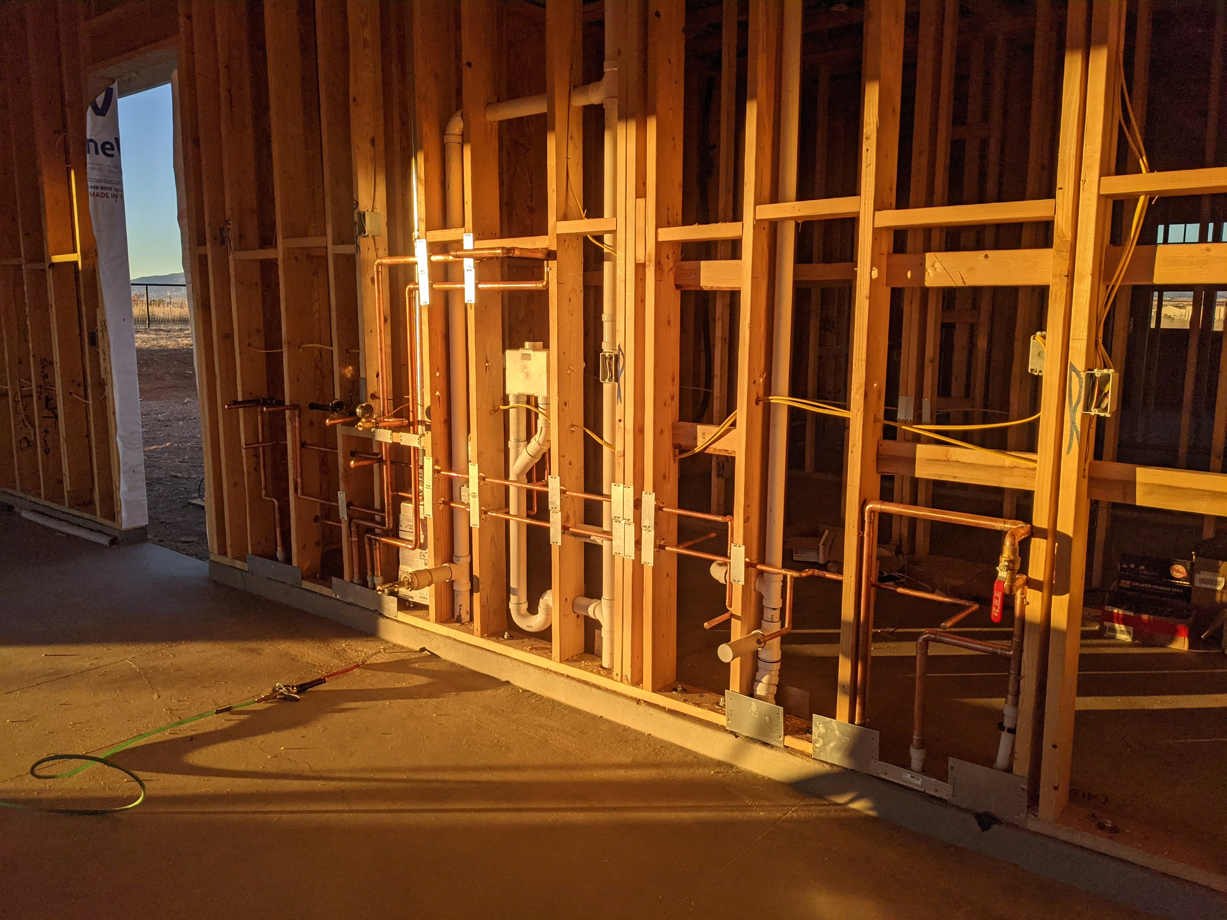 Copper and PVC plumbing lines installed in wood-framed residential construction