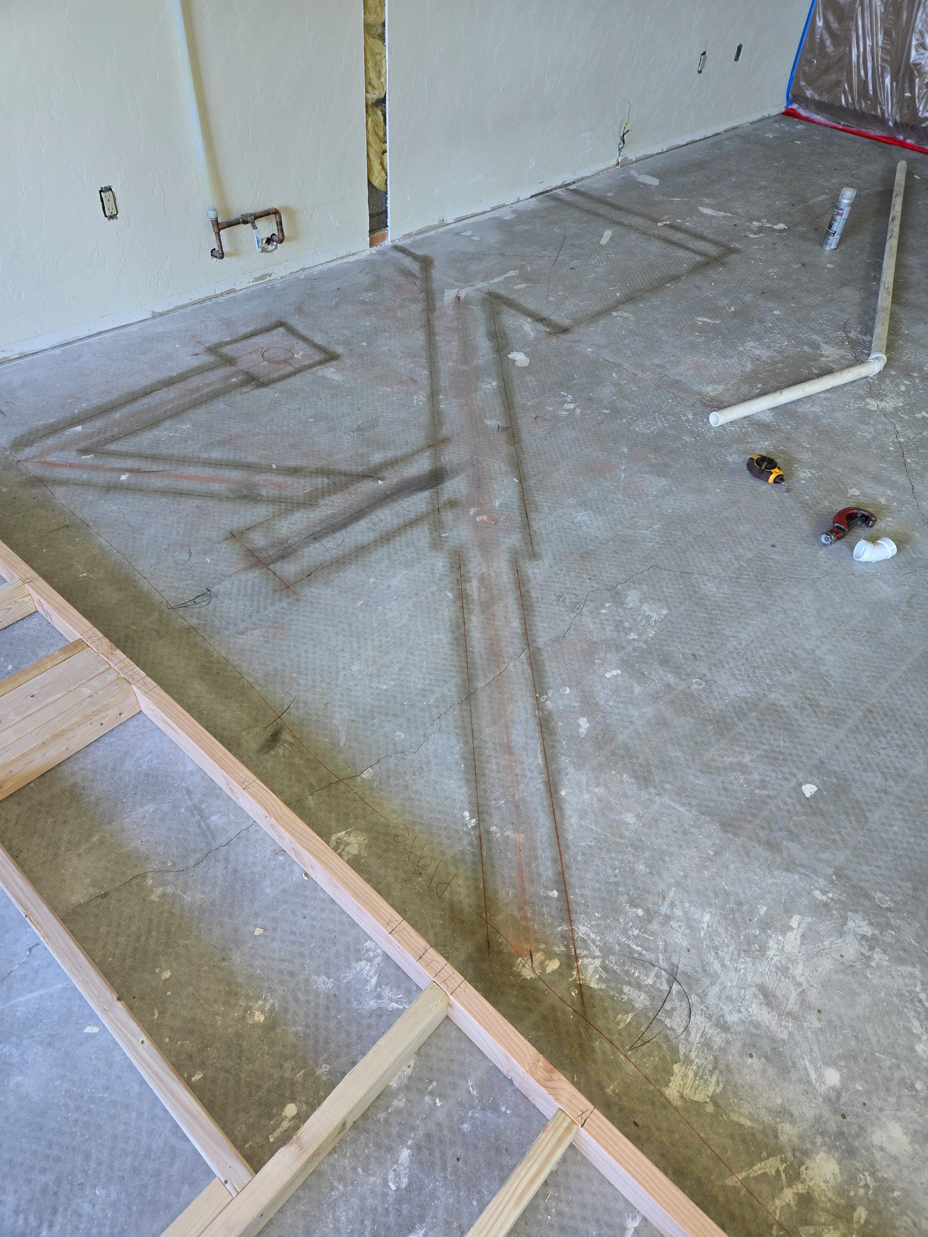 Rough-in plumbing with PEX tubing and copper lines on concrete slab
